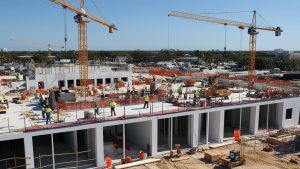 Construction site in North Lauderdale, Florida, with cranes, workers, and a partially completed building, highlighting the city's active development projects.