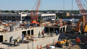 Construction site in Rockford, Illinois with workers and heavy machinery actively building a large structure, representing the city’s growing infrastructure and development.