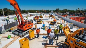 Modern residential construction project in Melbourne, Florida, showcasing a two-story building under development with workers and heavy equipment on-site.