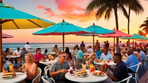 People enjoying a vibrant dining experience at a waterfront restaurant in Miami Beach, Florida, under colorful umbrellas during a picturesque sunset, reflecting the city’s lively atmosphere and coastal charm.