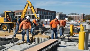 Construction workers in Norwalk, Connecticut, collaborating on a building project while wearing safety gear, illustrating teamwork and progress in infrastructure development.