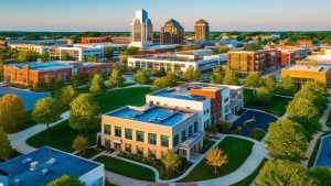 A scenic aerial view of downtown Carmel, Indiana, showcasing modern architecture, green spaces, and a vibrant business district during sunset.