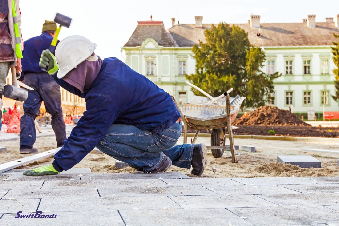 Paving blocks are stacked by workers on a city street.