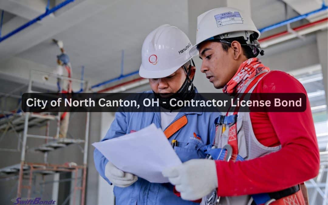 Two employees inside the built-out building are holding documents.