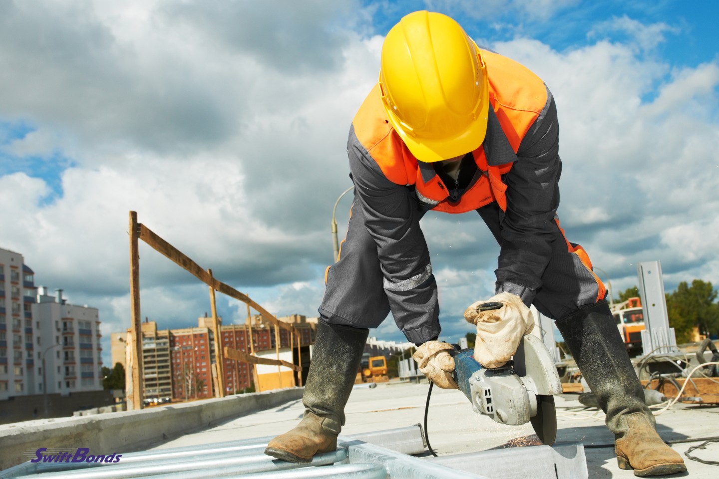 At the construction site, a builder uses a grinder machine to cut metal components.