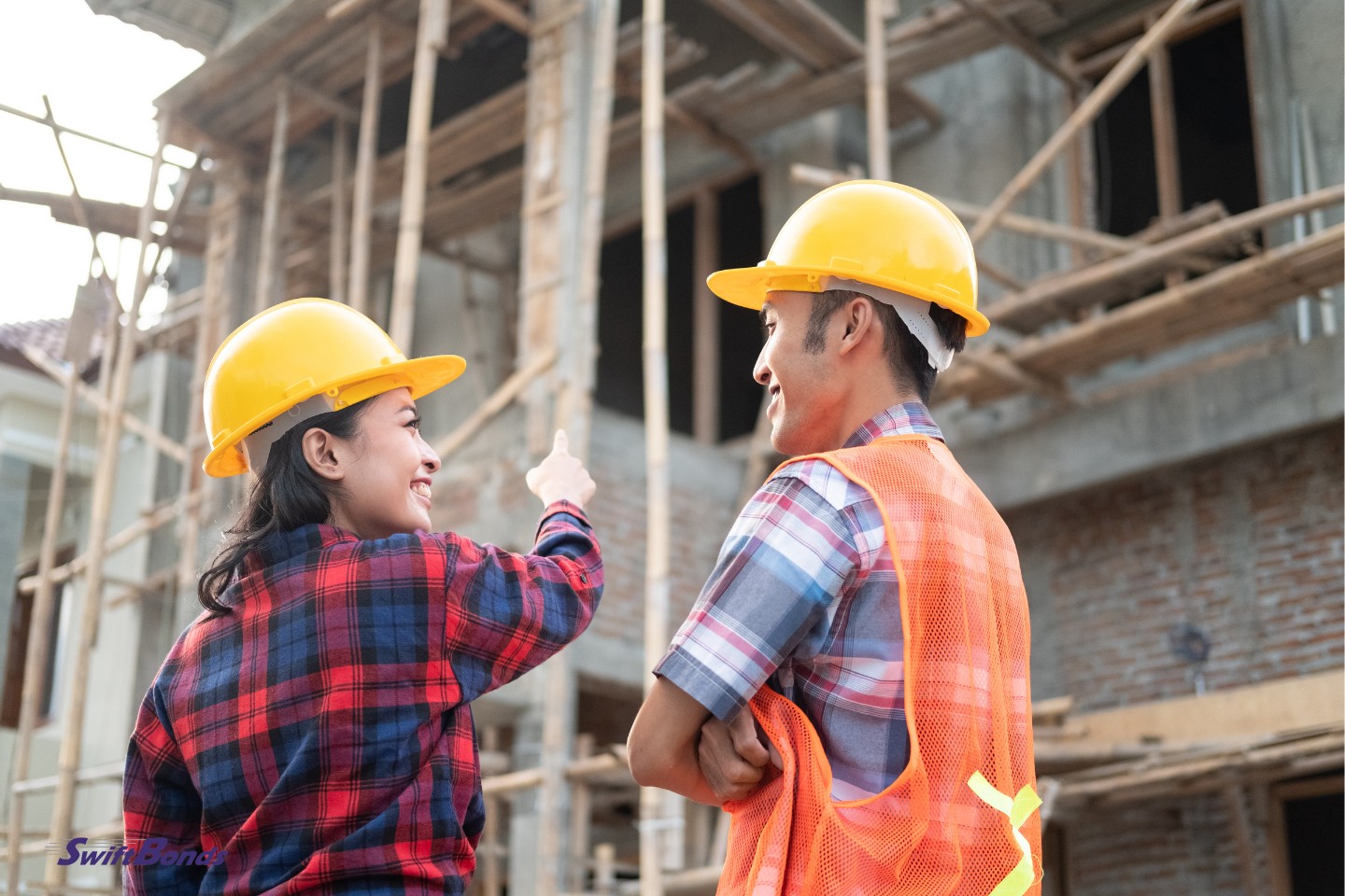 Asian manufacturers and female contractors are pointing fingers while donning safety helmets.