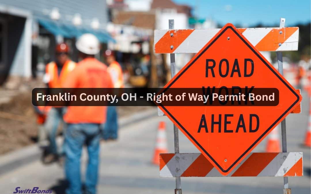 Signage for road repair ahead. In the background, contractors are working on the road or street.