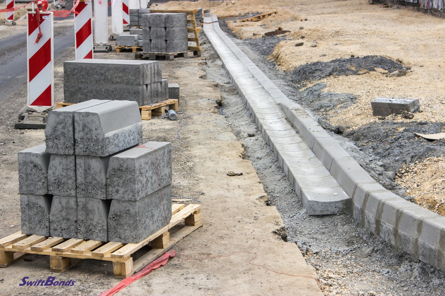 The sidewalk is being built, and the gutters and curb are being installed.