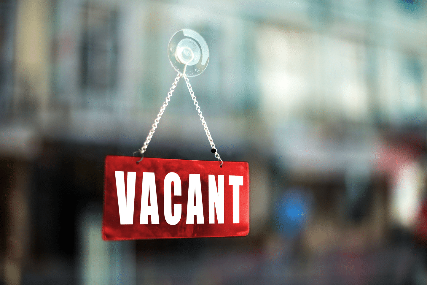 A red “Vacant” sign hanging on the glass door of an unoccupied property.