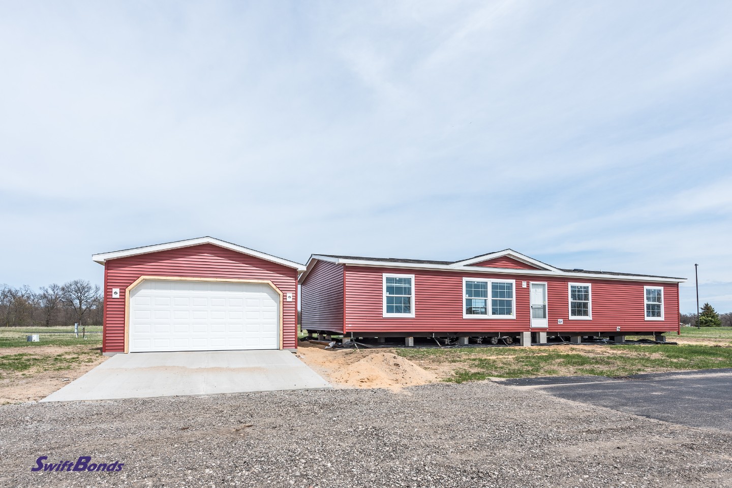There is still work to be done on the new manufactured home with the red vinyl sliding windows and white lineals.
