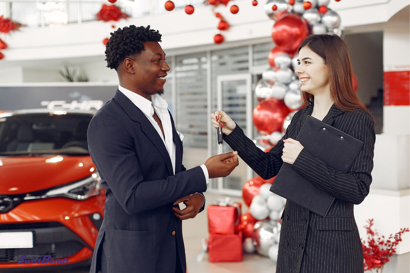 A man purchasing a vehicle.  The assistant assists in selecting a vehicle.