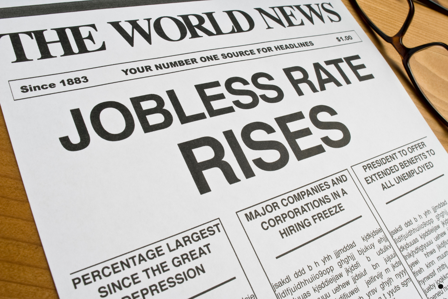 Newspaper front page with a bold headline announcing a rise in the jobless rate.