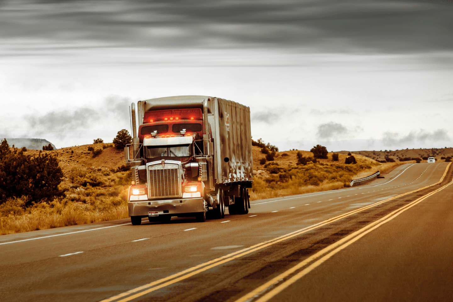 Large commercial truck hauling cargo on an open rural highway.