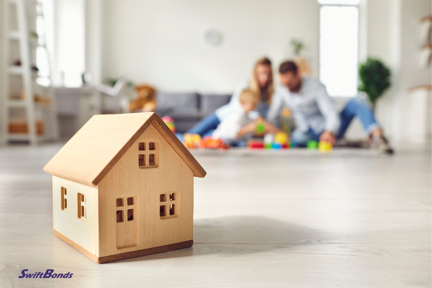 On the floor of a comfortable room is a small wooden house.