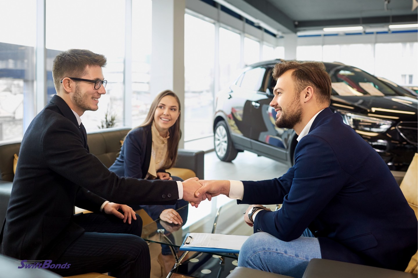 In a car dealership, a couple purchases a vehicle.