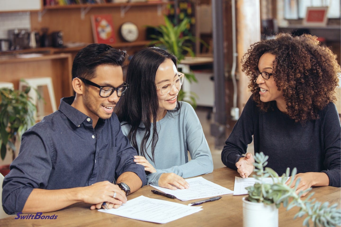 A couple is speaking with a mortgage broker at the office.