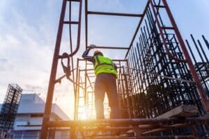 A contractor is wearing a safety vest and a hardhat.