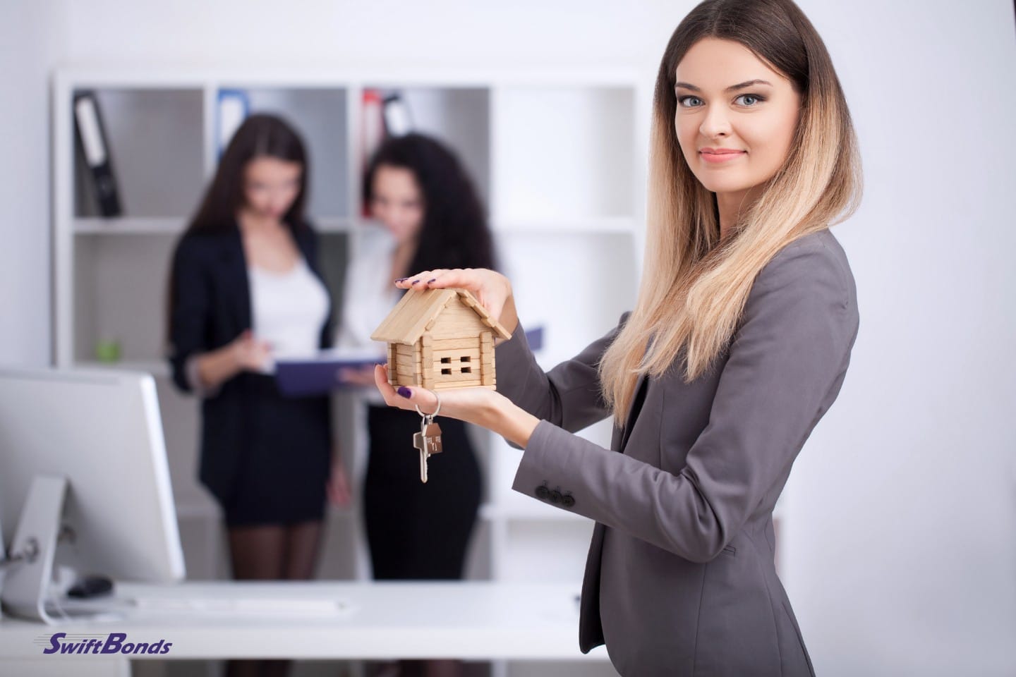 Real estate agent displays a house model in the office.
