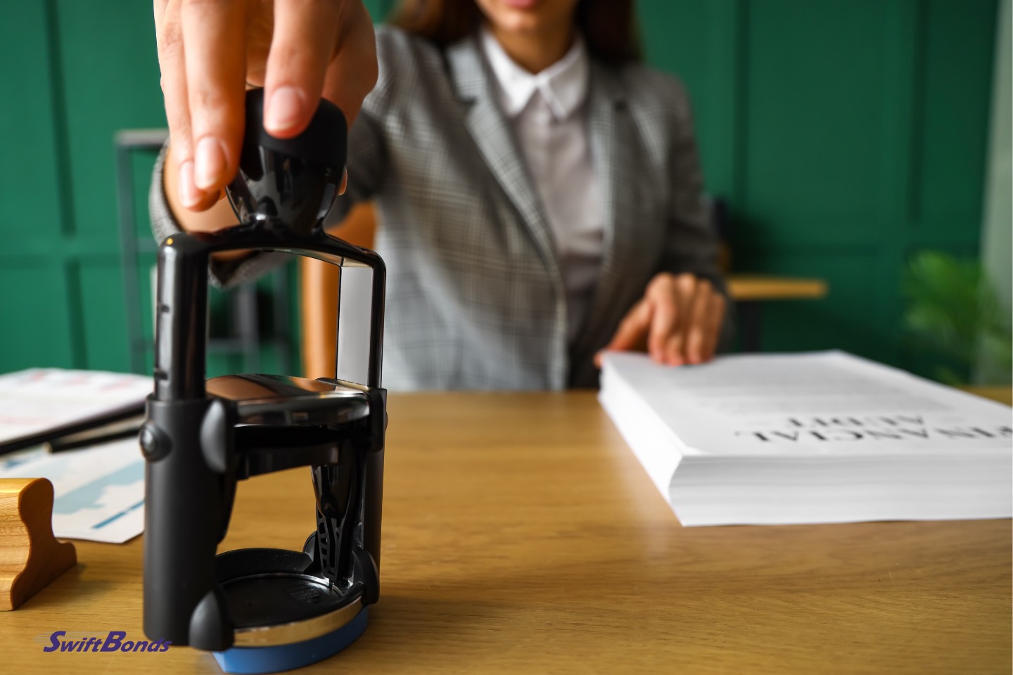 A female notary public attaches her seal to documents in the office.
