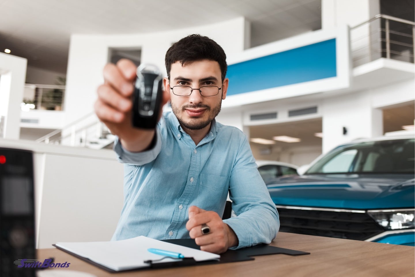 A vehicle salesman holds a car key.