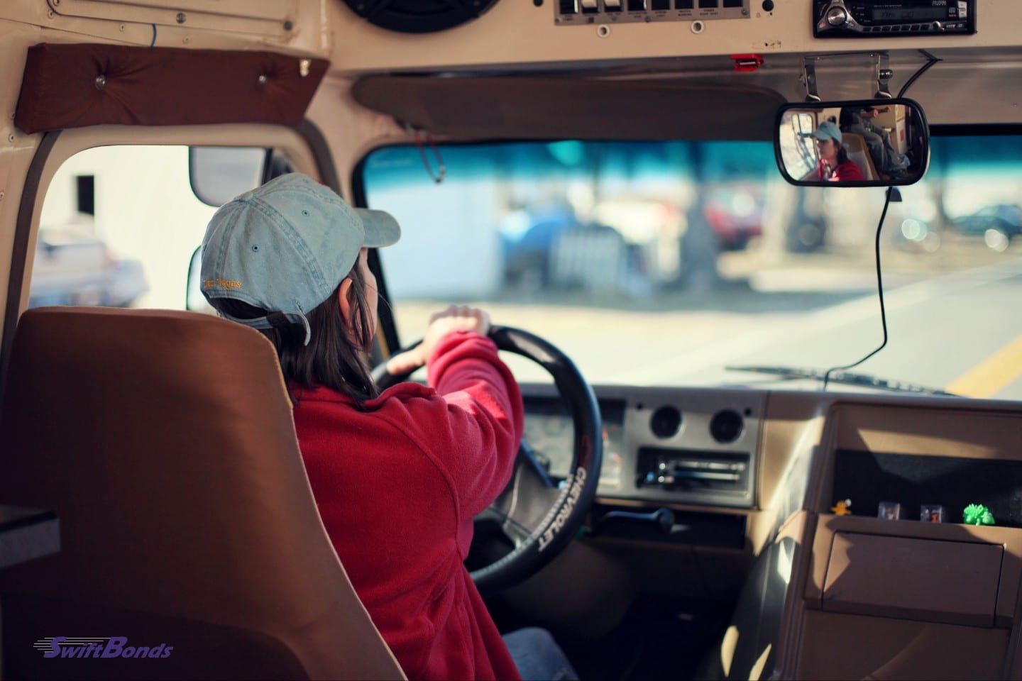 A long-distance female motorist wearing a cap.