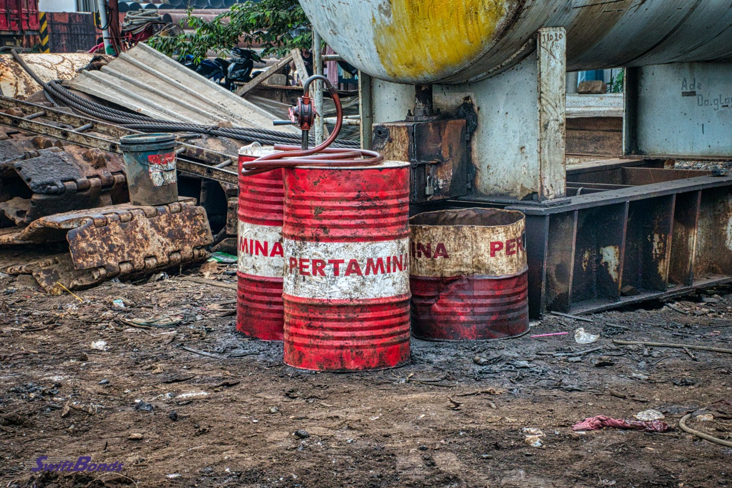 Barrels of aged metal dumped in a landfill.