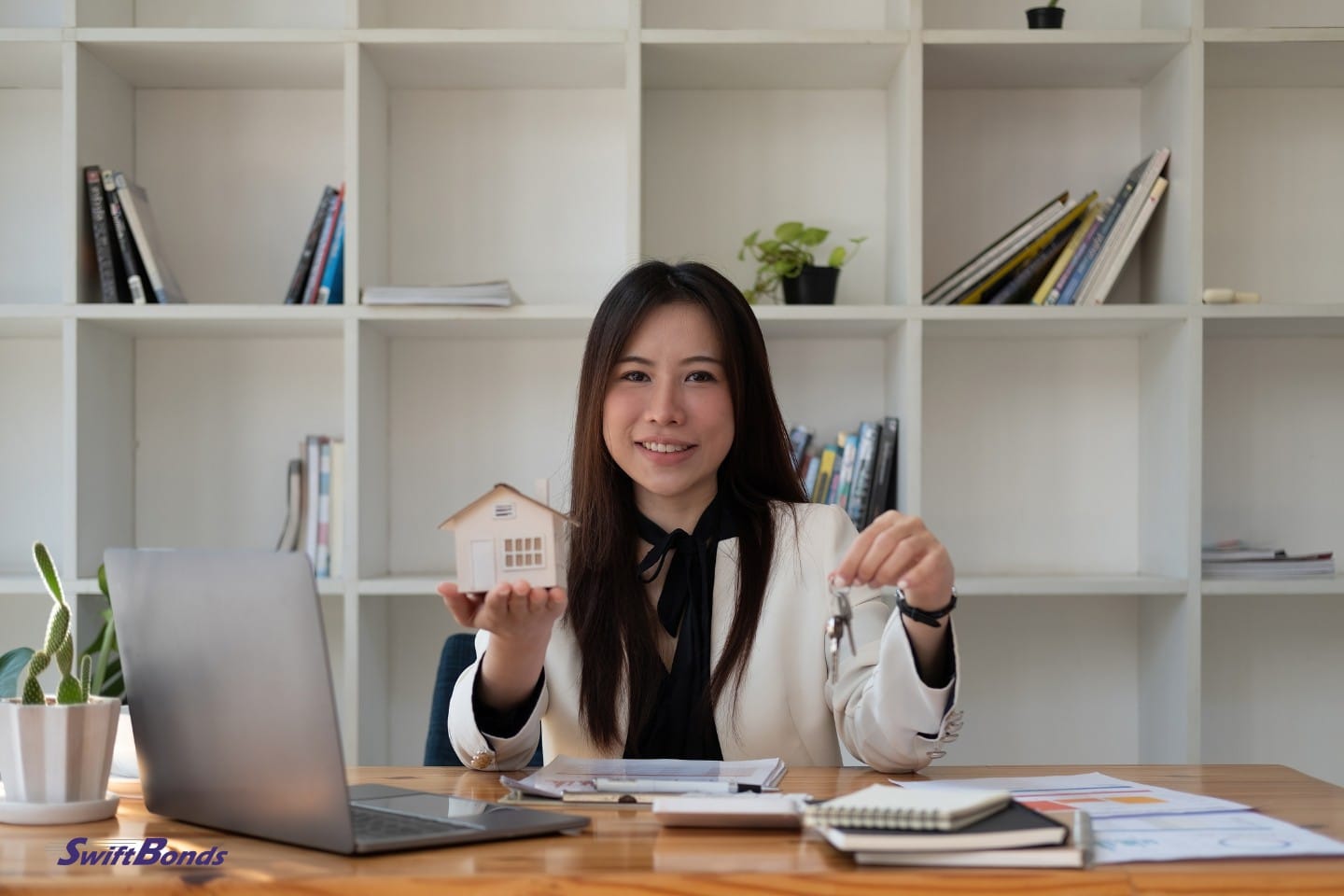 Asian businesswoman holding a real estate hand in a portrait.