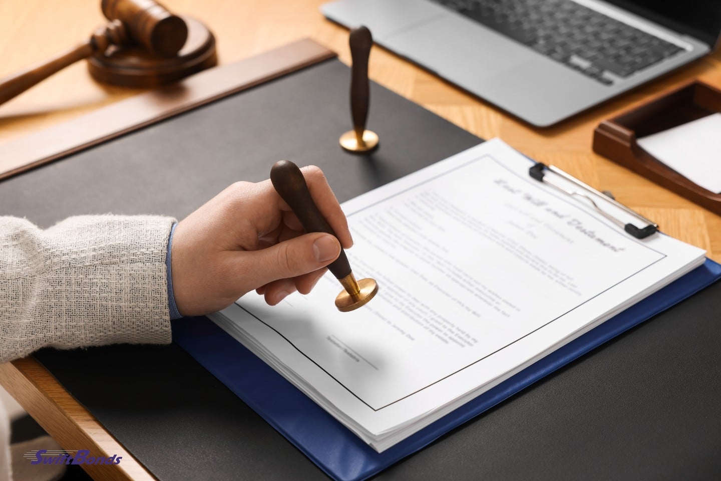 At the table, a notary stamps the document.