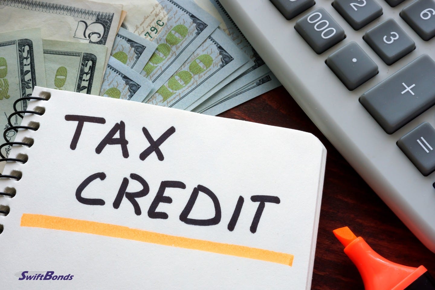 On a table is a notebook with a tax credit sign.