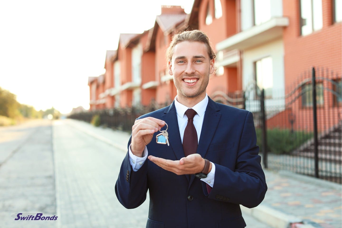 Outside, a male real estate agent holds a key.