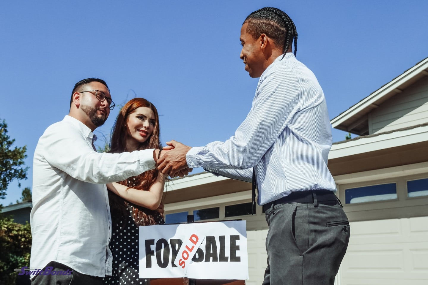 A realtor and a man shaking hands.