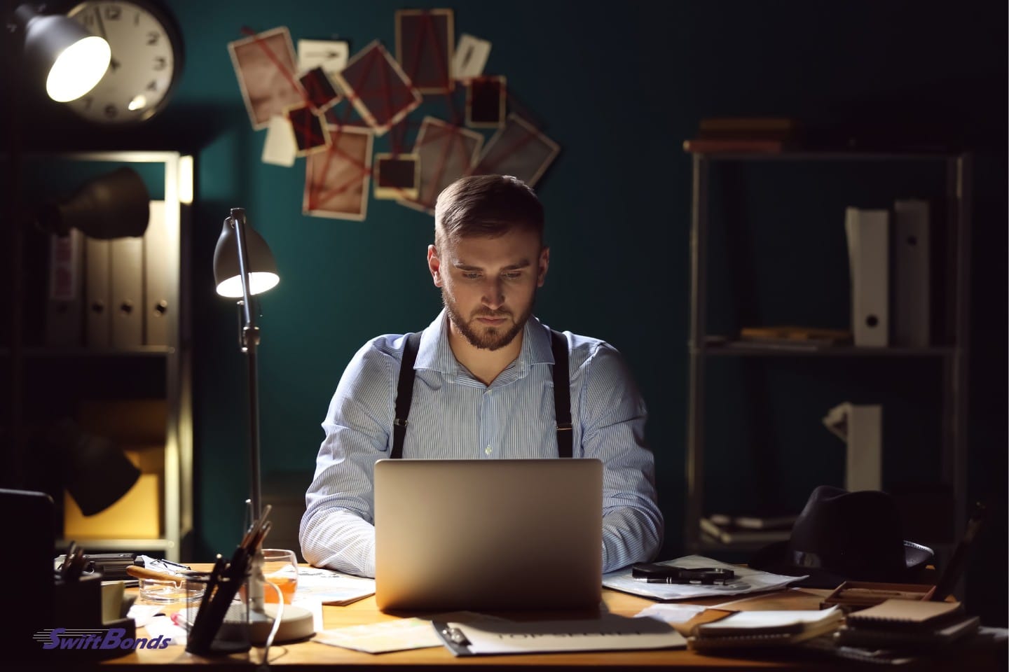 In the office, a detective uses a laptop to process evidence.