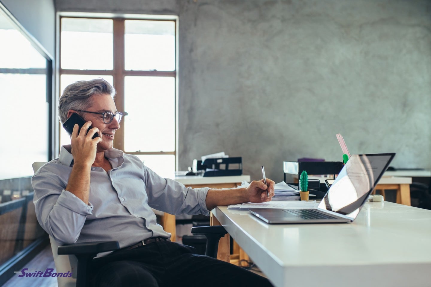 In the office, a collection agent is on the phone.