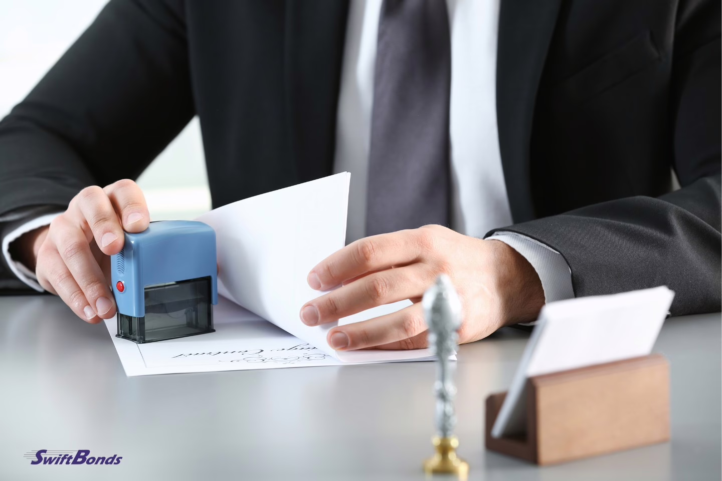 At the table, a male notary is stamping a document.