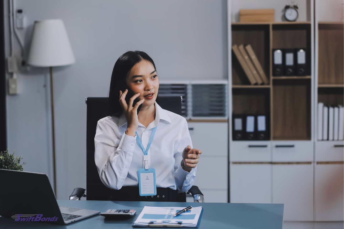 A woman on the phone discussing a new hire's assignment.