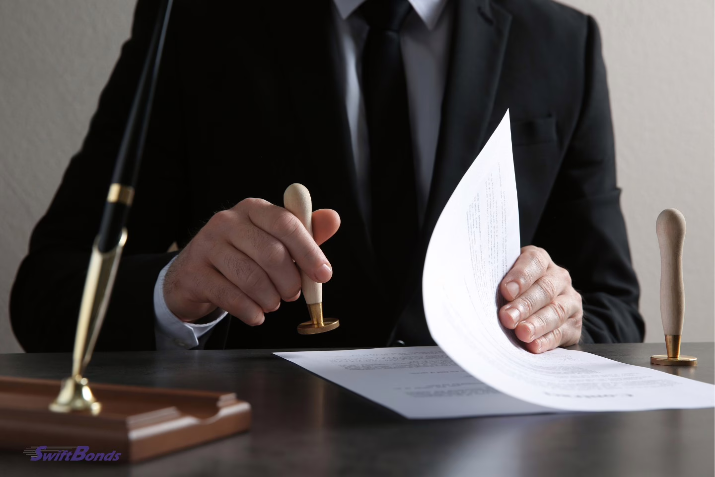 At the table, a male notary is stamping a document.