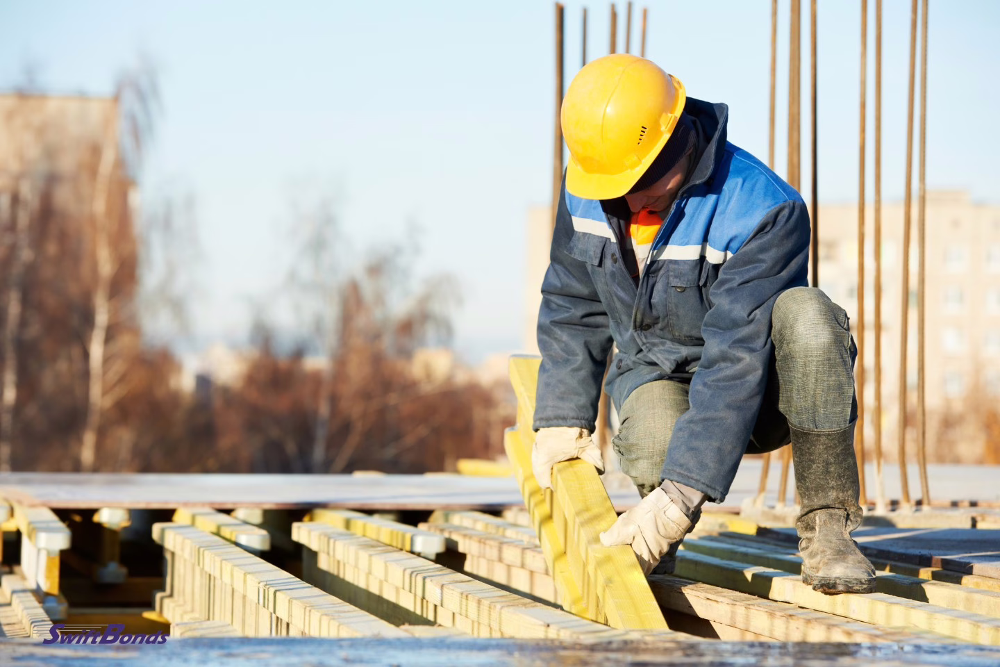 Formwork is being prepared by a construction worker.