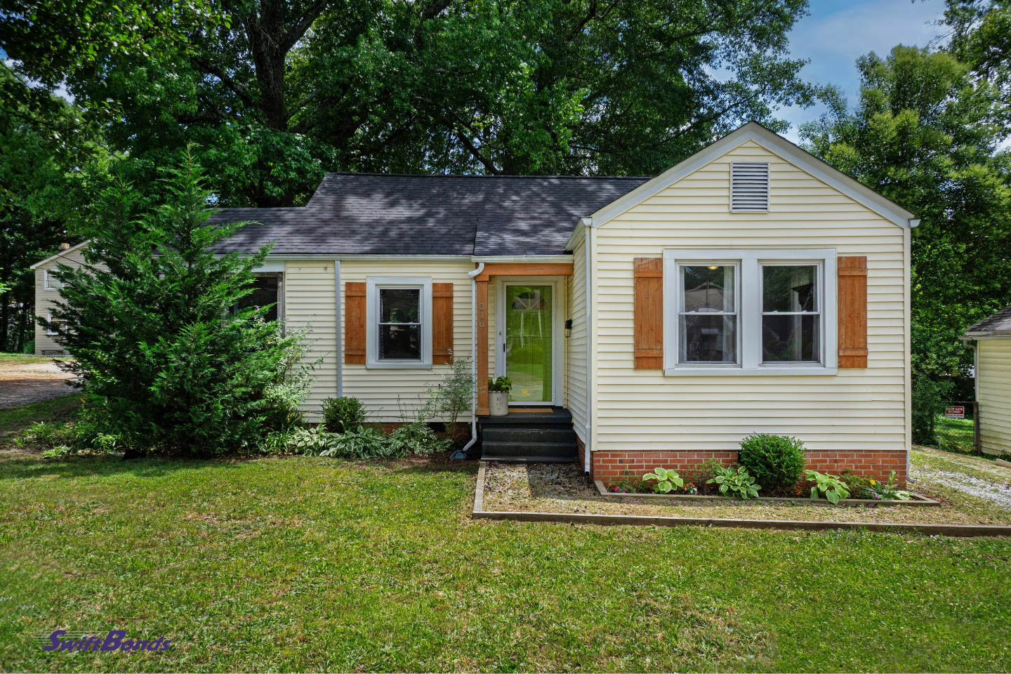charming manufactured home with vegetation in the suburbs.